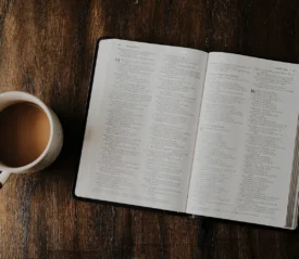 open bible with a cup of coffee on a table top