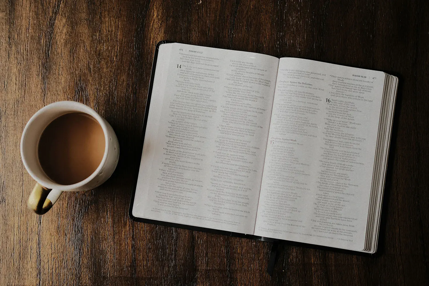 open bible with a cup of coffee on a table top