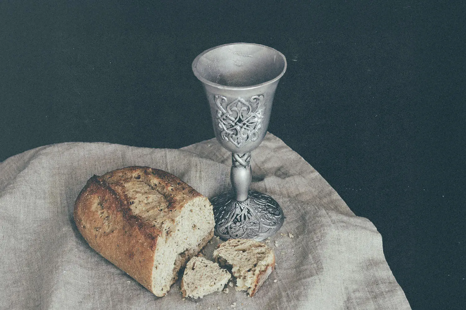 bread and goblet on napkin on a table