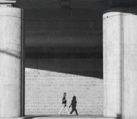 Woman walking through breezeway with two concrete pillars in view