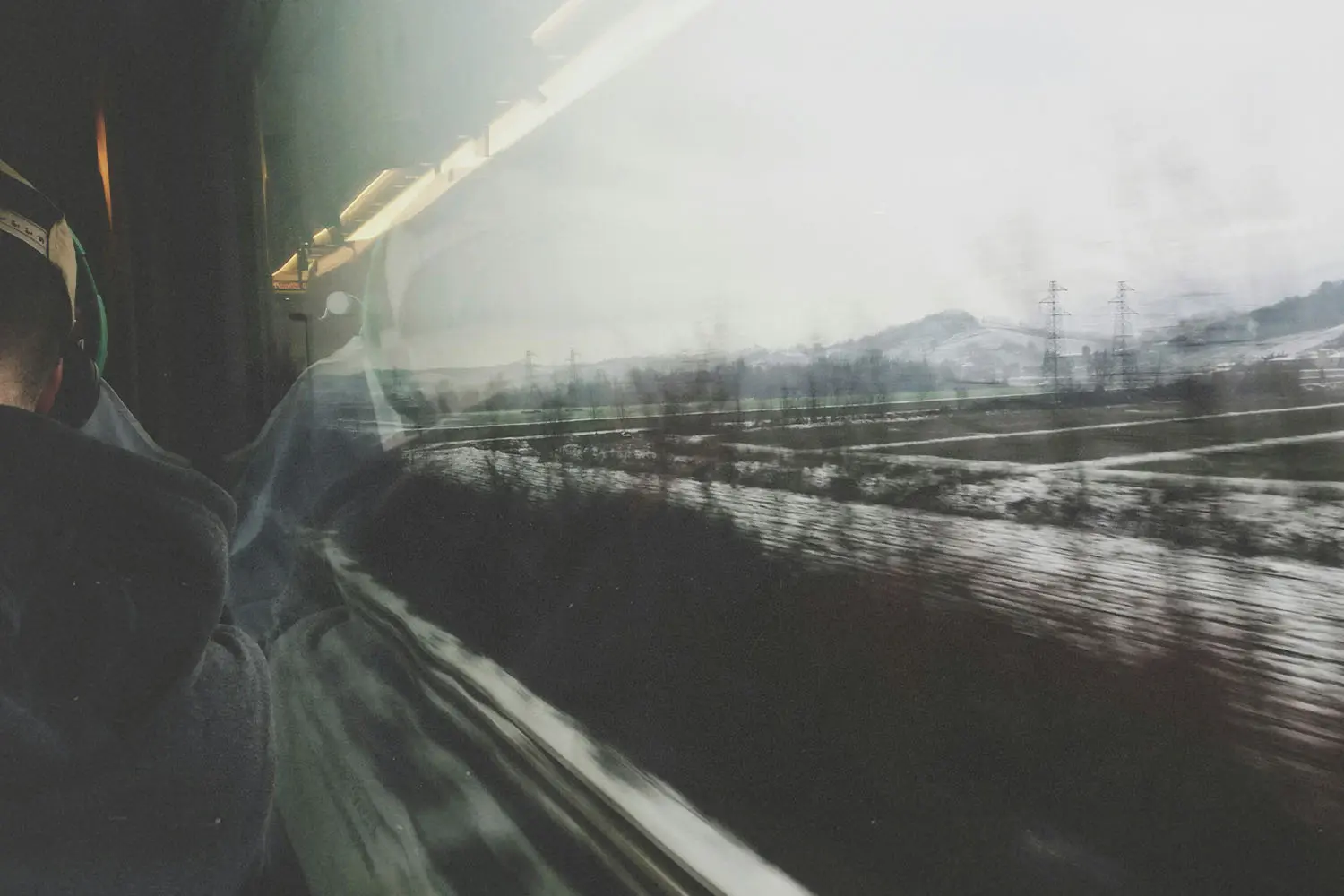 looking out a train window at a treed snowy landscape