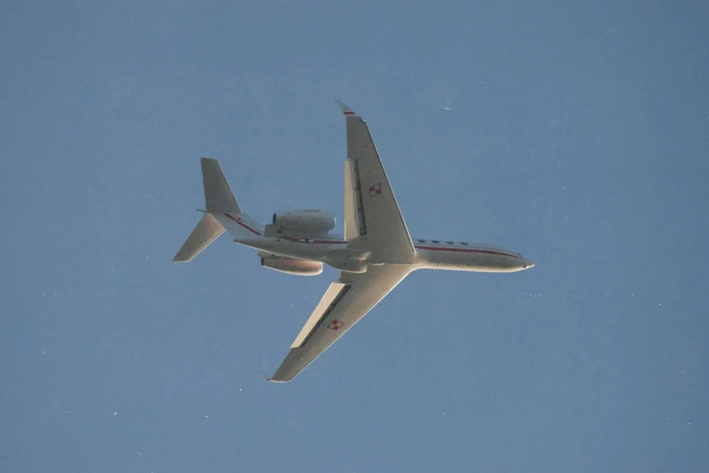 Airplane flying through cloudless blue sky