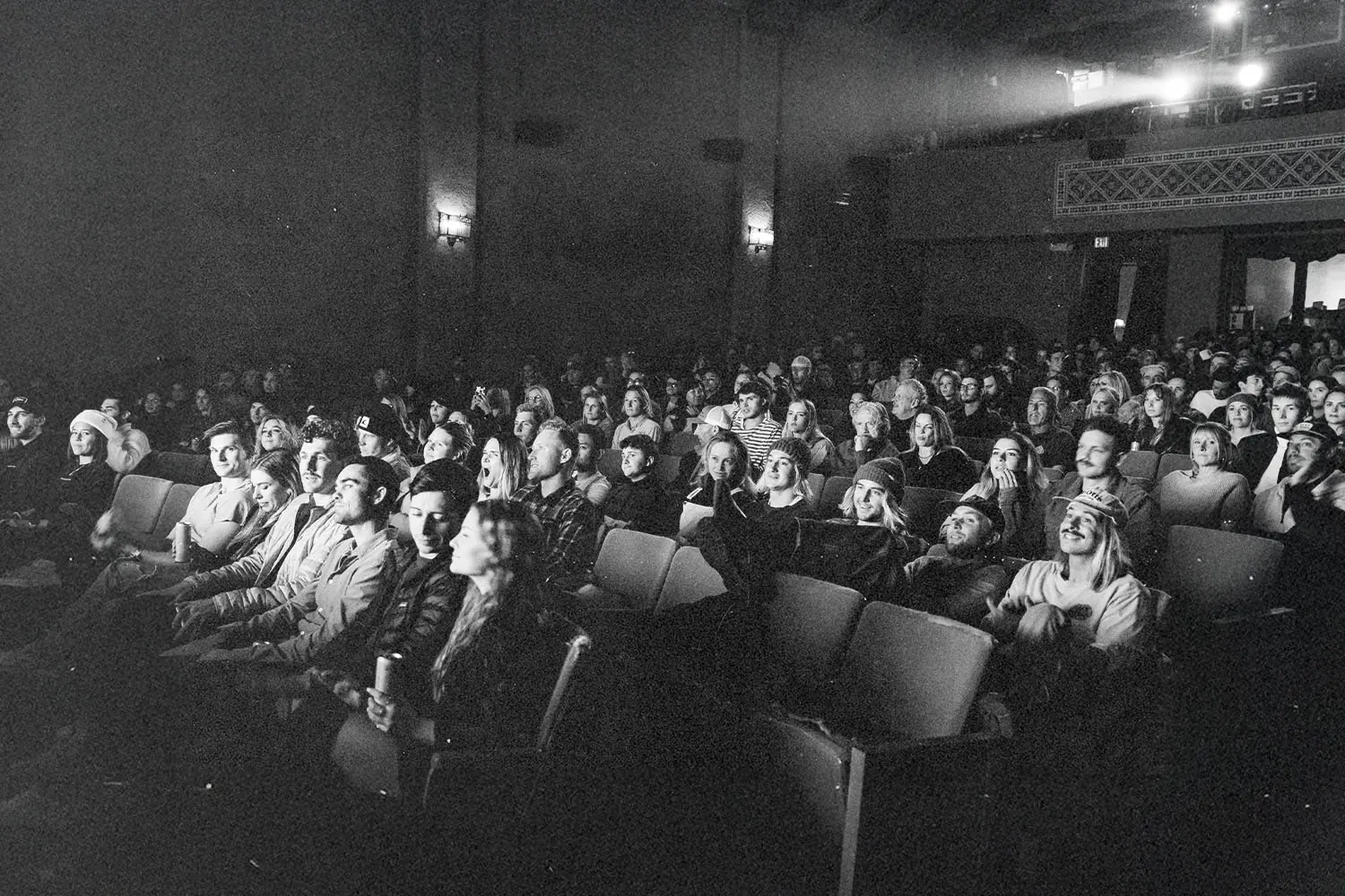 Large audience seated in a theater watching a performance or presentation
