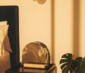 arched mirror on nightstand next to bed