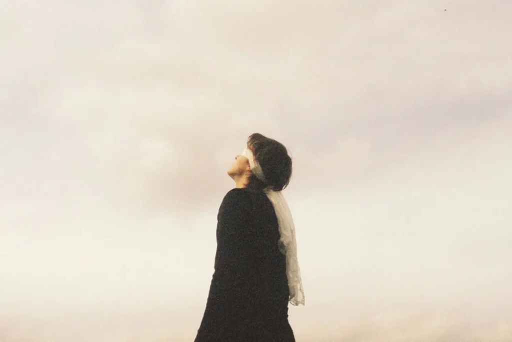 woman looking up with a cloudy background