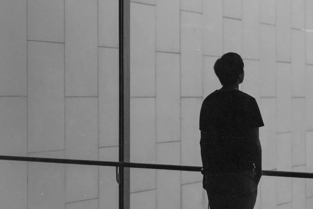 Single man standing at a glass window