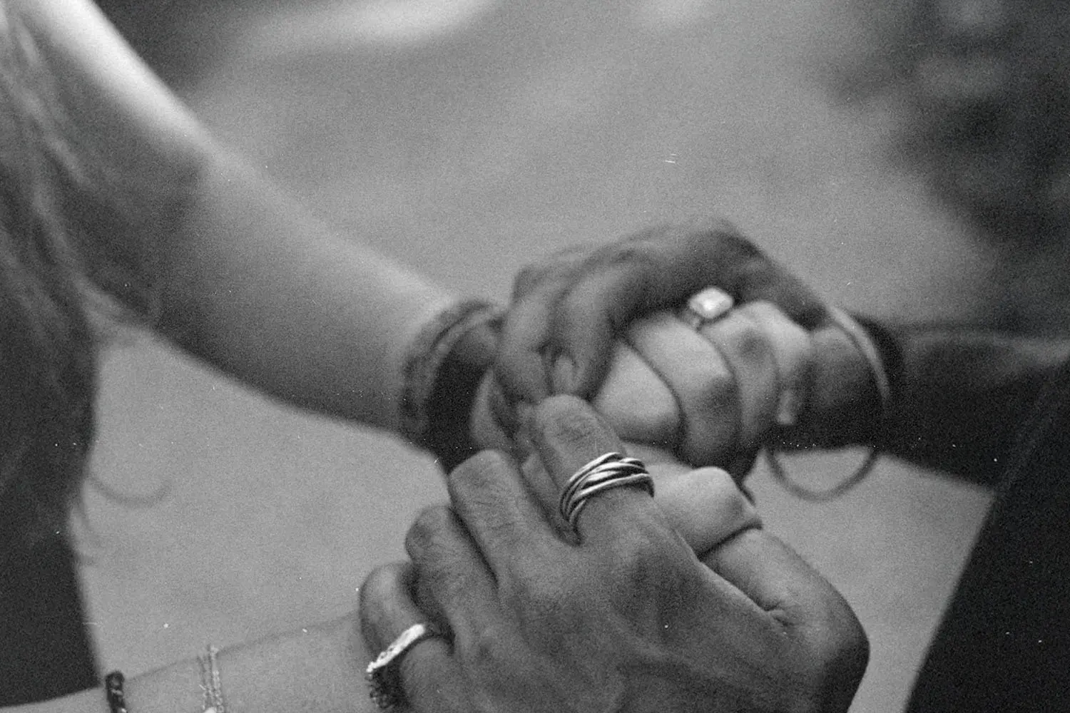 Close-up of multiple hands gently holding each other in a supportive gesture