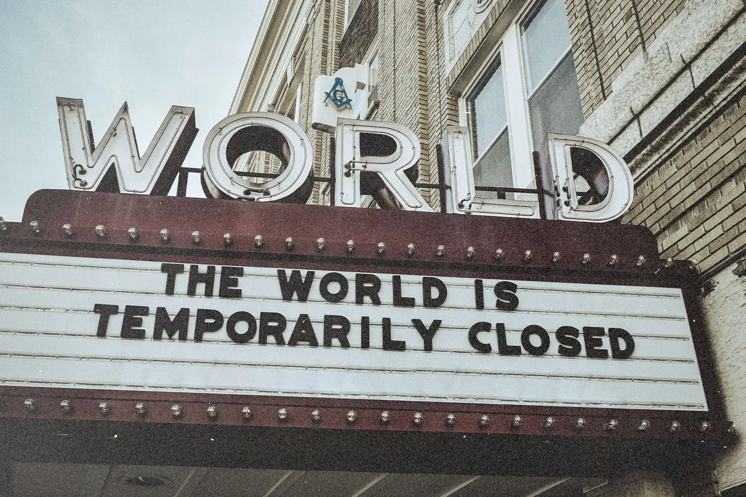 Vintage theater marquee reading “THE WORLD IS TEMPORARILY CLOSED” displayed under bold retro lettering