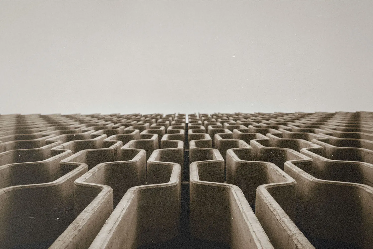 A repeating pattern of concrete architectural structures receding into the distance.
