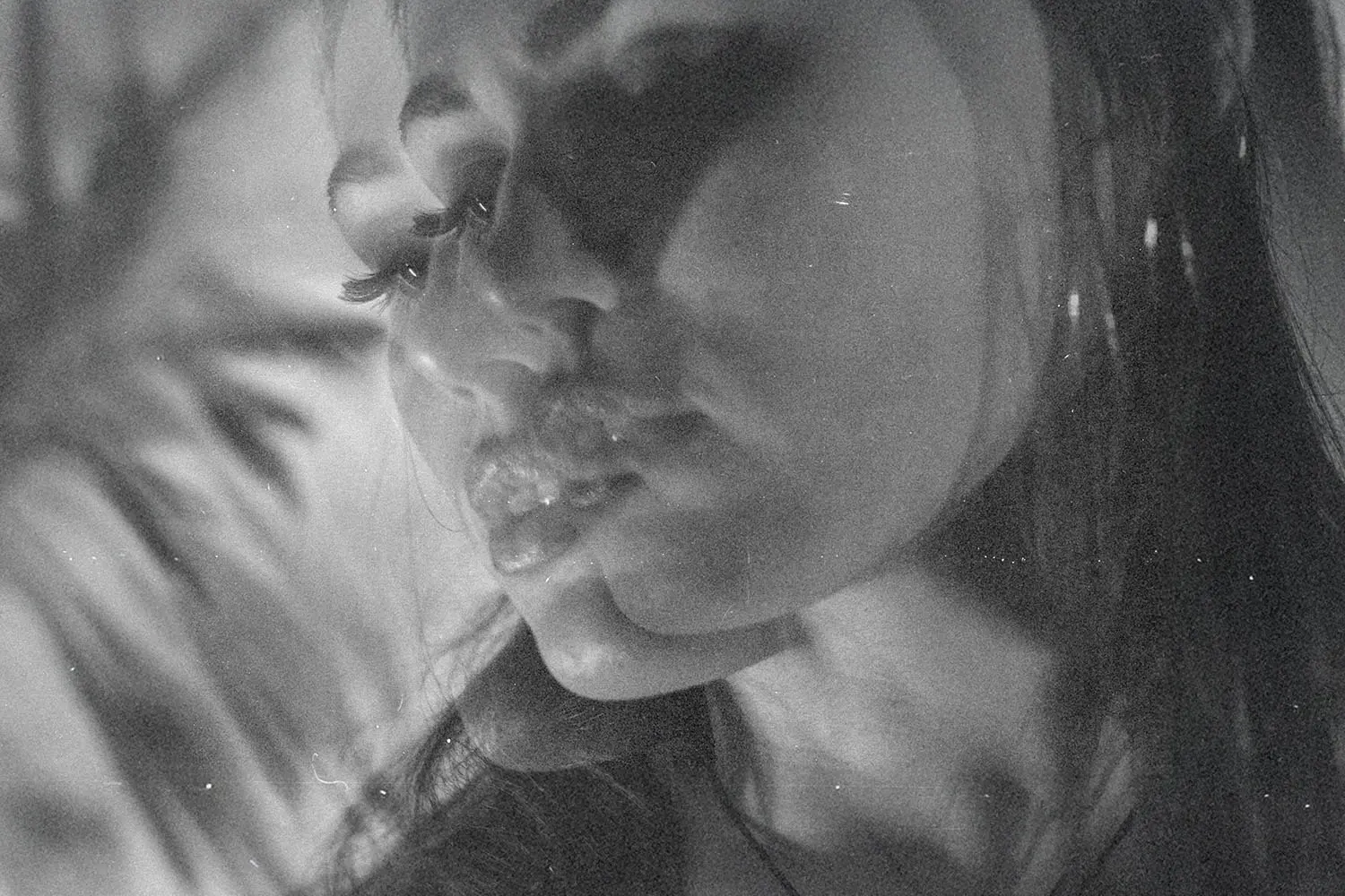 A double‑exposure black‑and‑white portrait showing overlapping facial profiles.