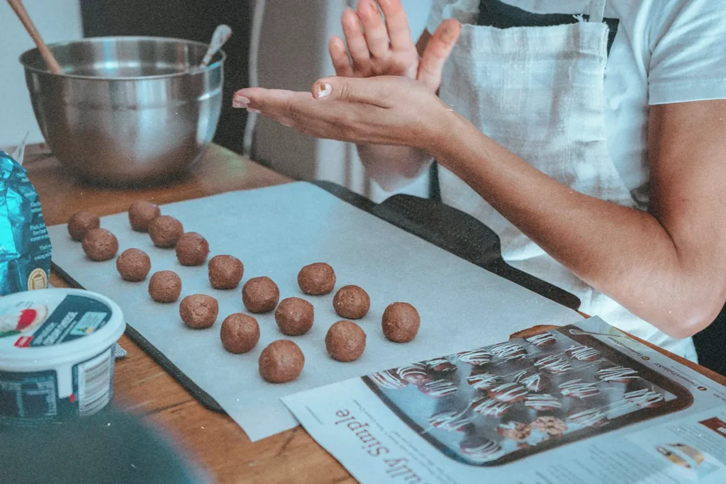 Girl in the kitchen preparing cookies to be baked, representing Ways to Give This Christmas that aren't money