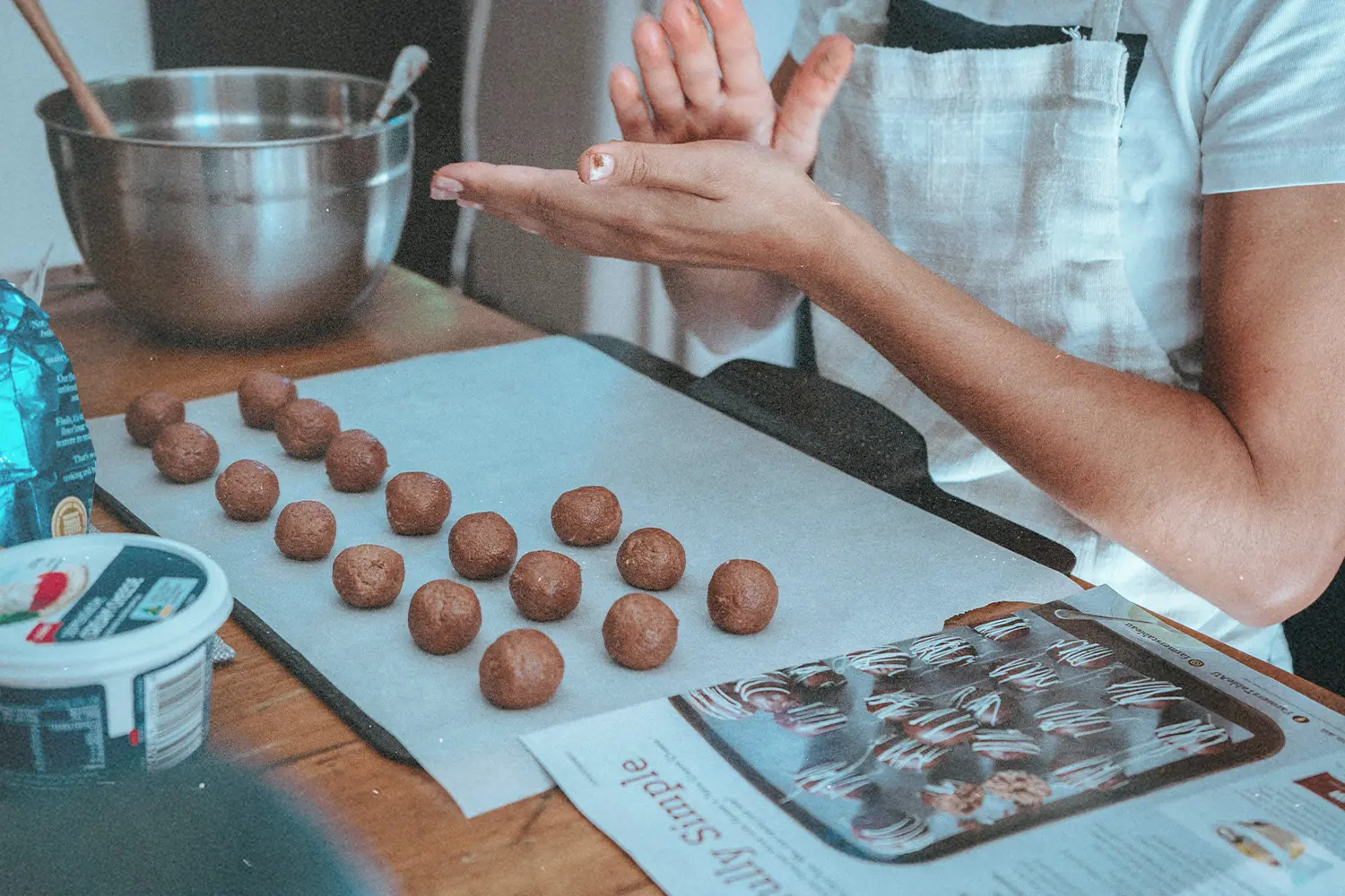 Girl in the kitchen preparing cookies to be baked, representing Ways to Give This Christmas that aren't money