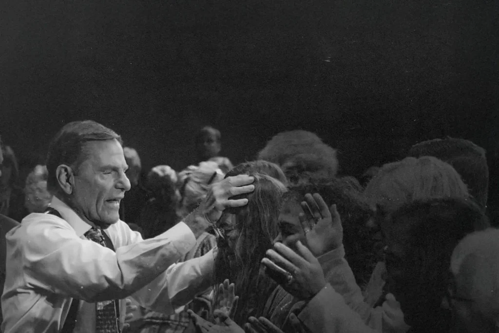Kenneth Copeland praying over people