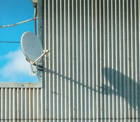 satellite dish on the side of a metal building