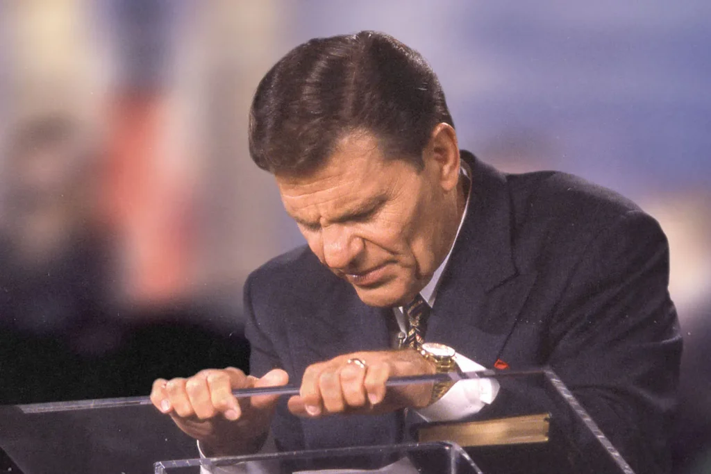 Kenneth Copeland praying at a podium