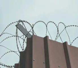 barbed wire atop a steel fence