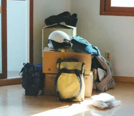 Pile of stuff covering boxes in the corner of an empty room