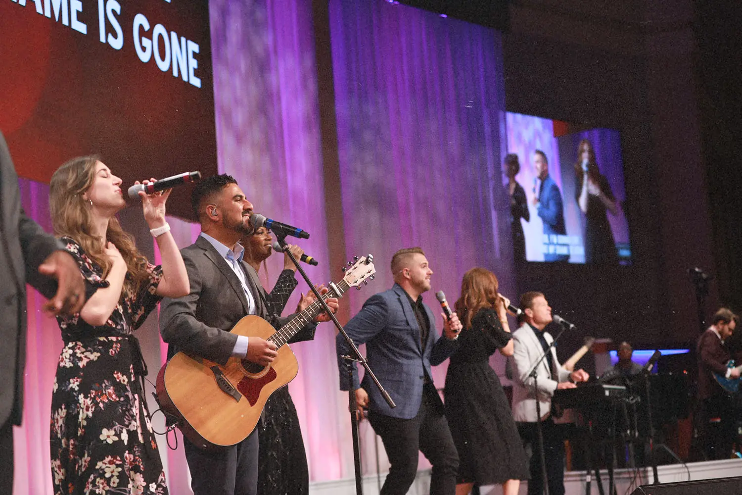 worship team in suits and dresses singing and playing instruments