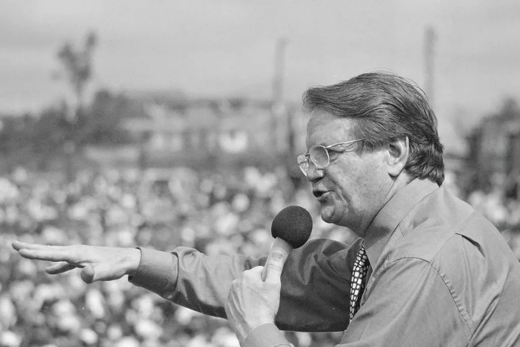 Reinhardt Bonnke speaking into a microphone at a crusade
