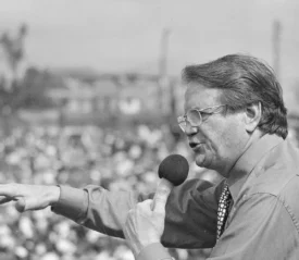 Reinhardt Bonnke speaking into a microphone at a crusade