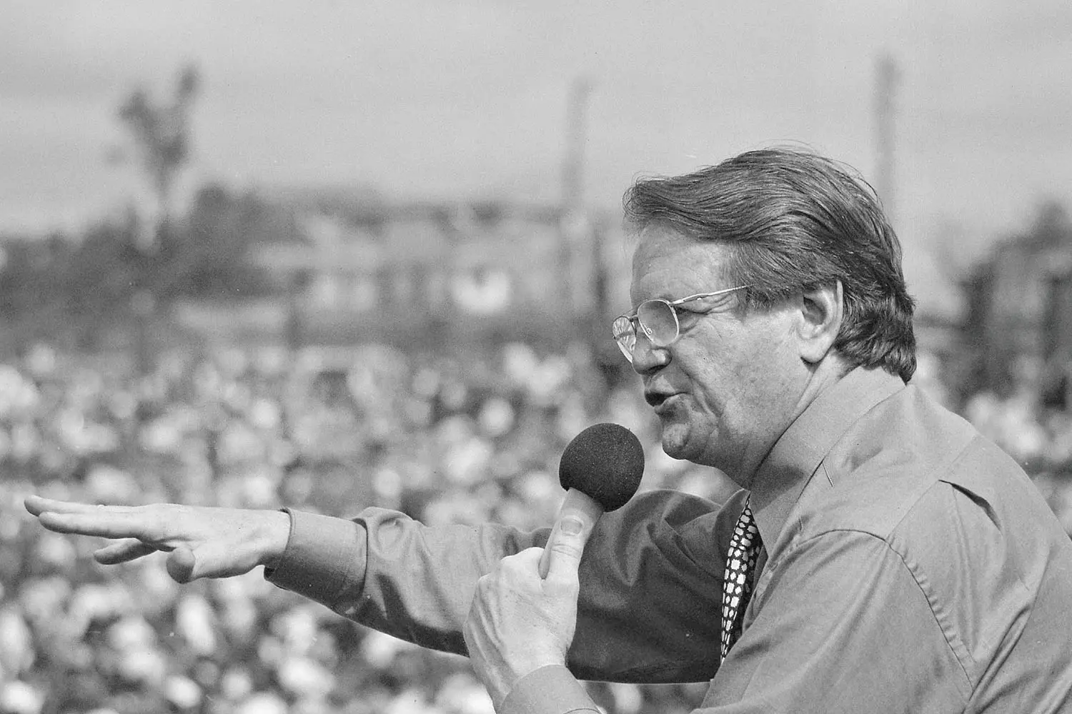 Reinhardt Bonnke speaking into a microphone at a crusade