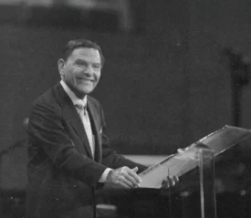 Kenneth Copeland smiling at a podium