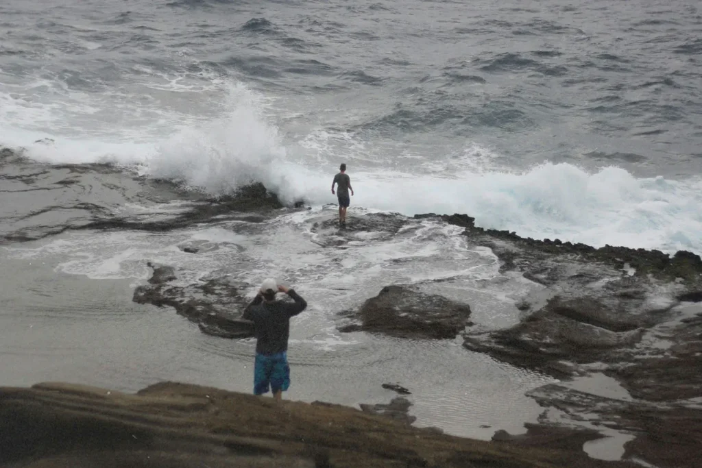 two people on a rocky shoreline
