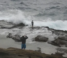two people on a rocky shoreline