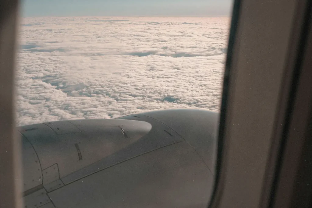 View of a bed of clouds and engine from an airplane window