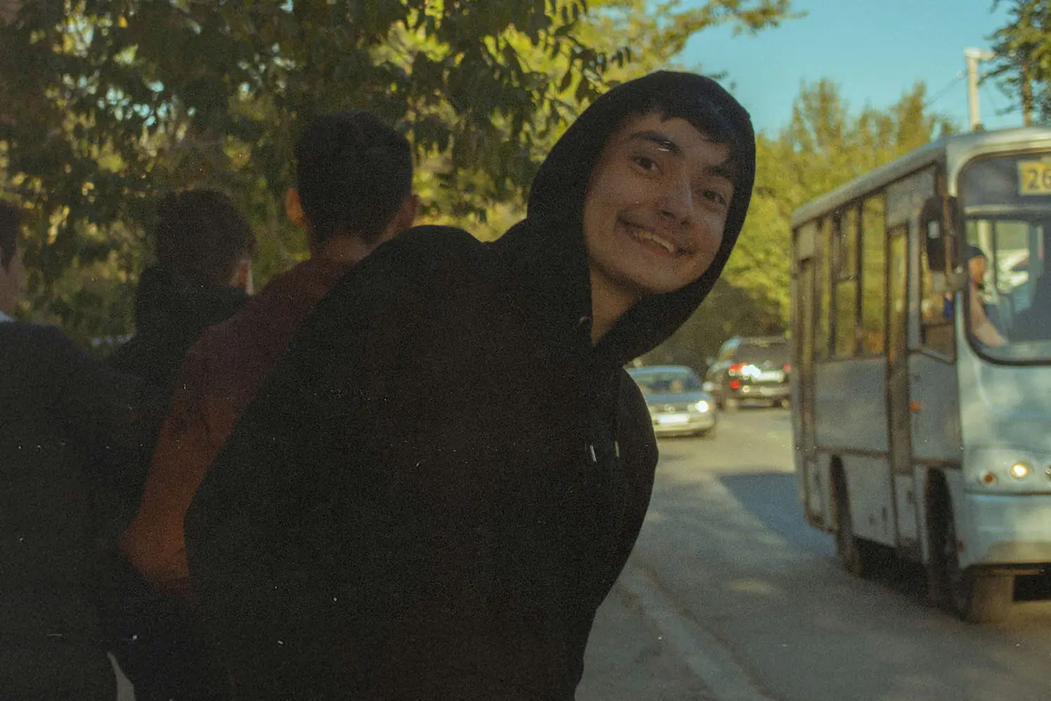 Young boy in dark hoodie smiling