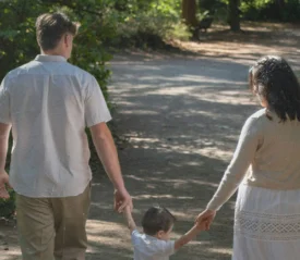 Family of three walking down a path