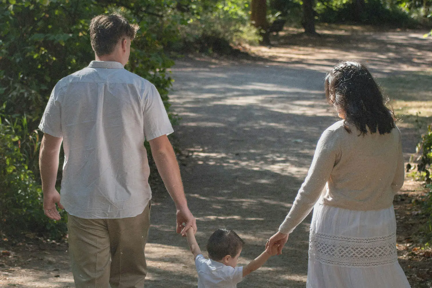 Family of three walking down a path