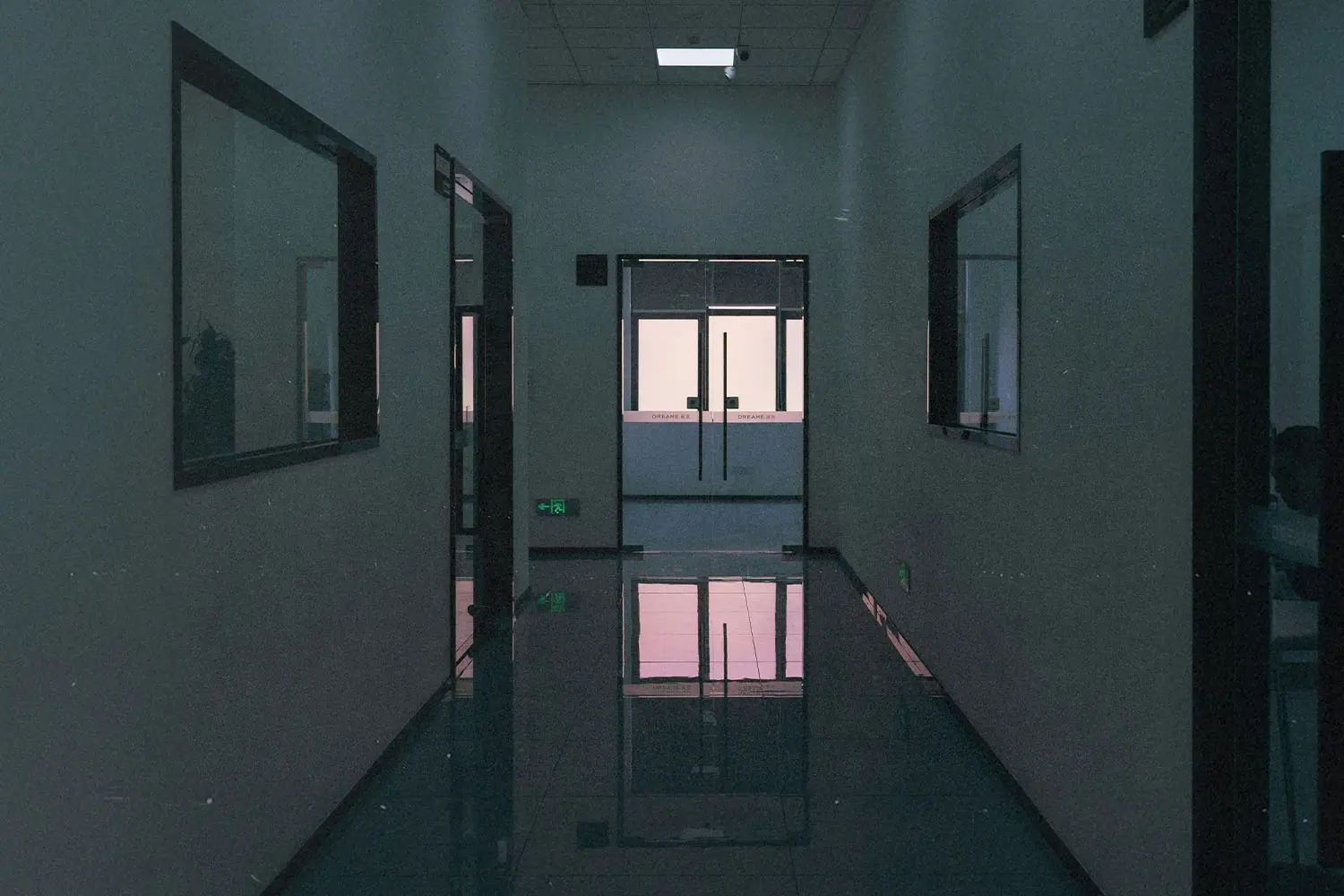 Dimly lit hallway of hospital leading to the front desk