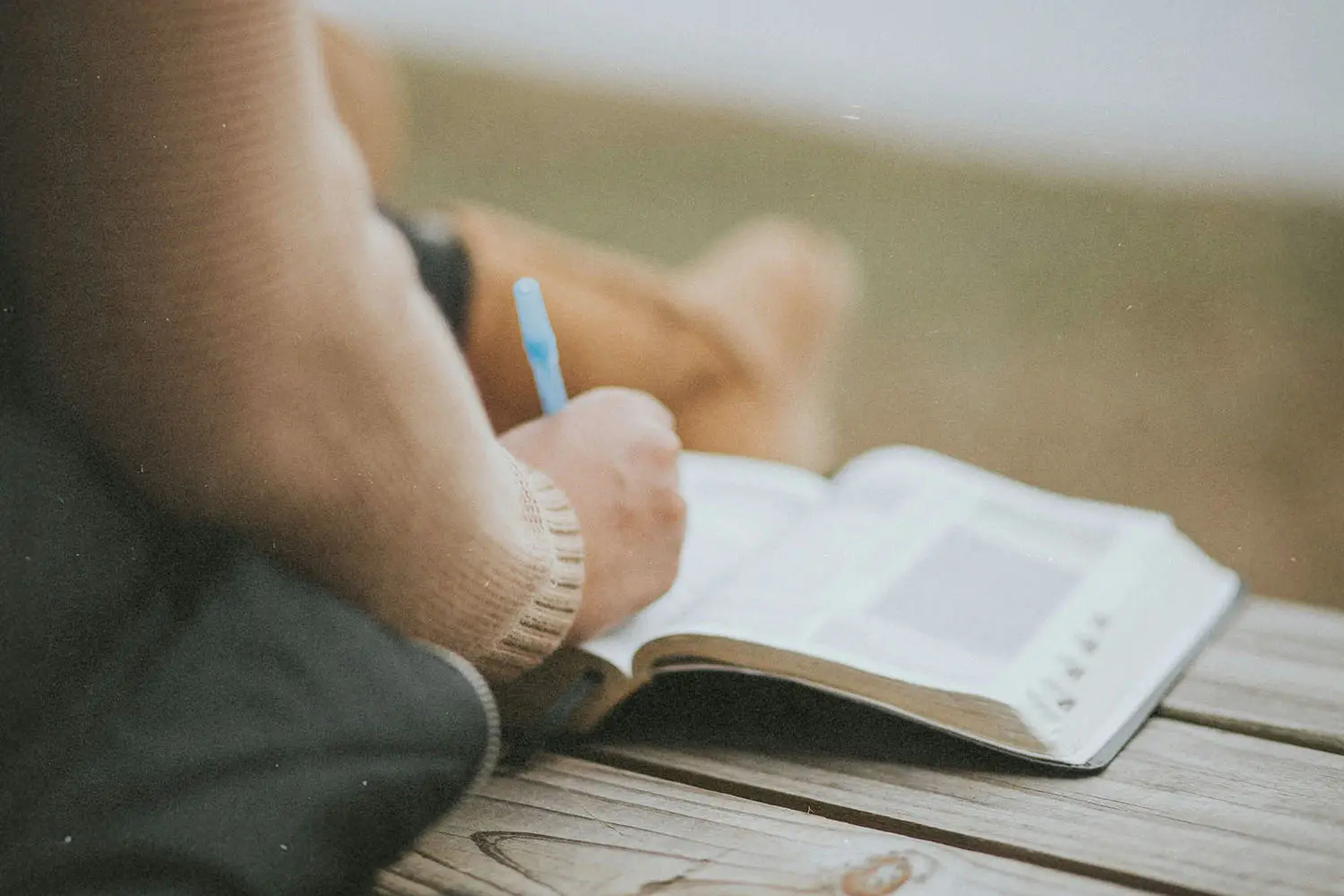 Person writing in their Bible