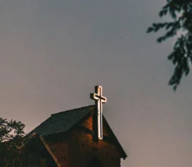 Neon white cross on the front of building roof