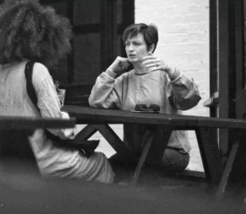 Two women talking at a picnic table