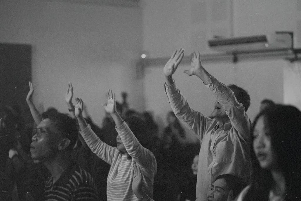 Crowd of people lifting hands and heads in worship