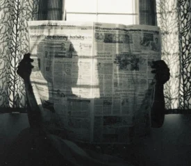 Silhouette of person holding a newspaper