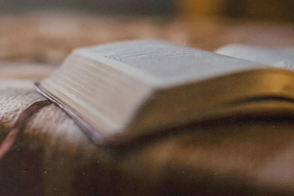Bible lying open on a textured blanket with pages softly illuminated