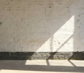 Shadow of window panes on a concrete wall