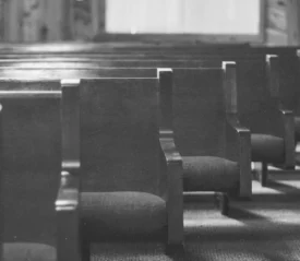 black and white photo of empty church pews