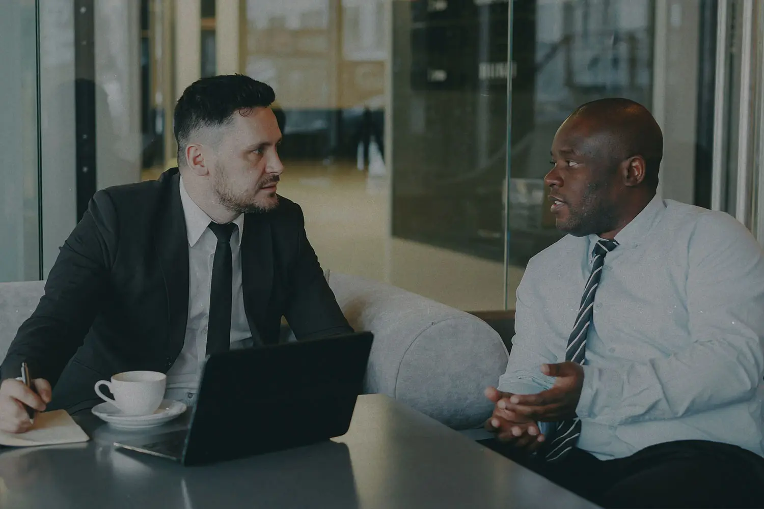 two business men talking at a desk in an office
