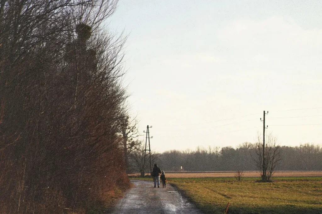 Father and son walking to the end of a dirt road