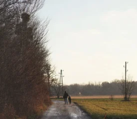 Father and son walking to the end of a dirt road