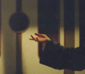 Outstretched hand in soft, warm light with blurred background elements