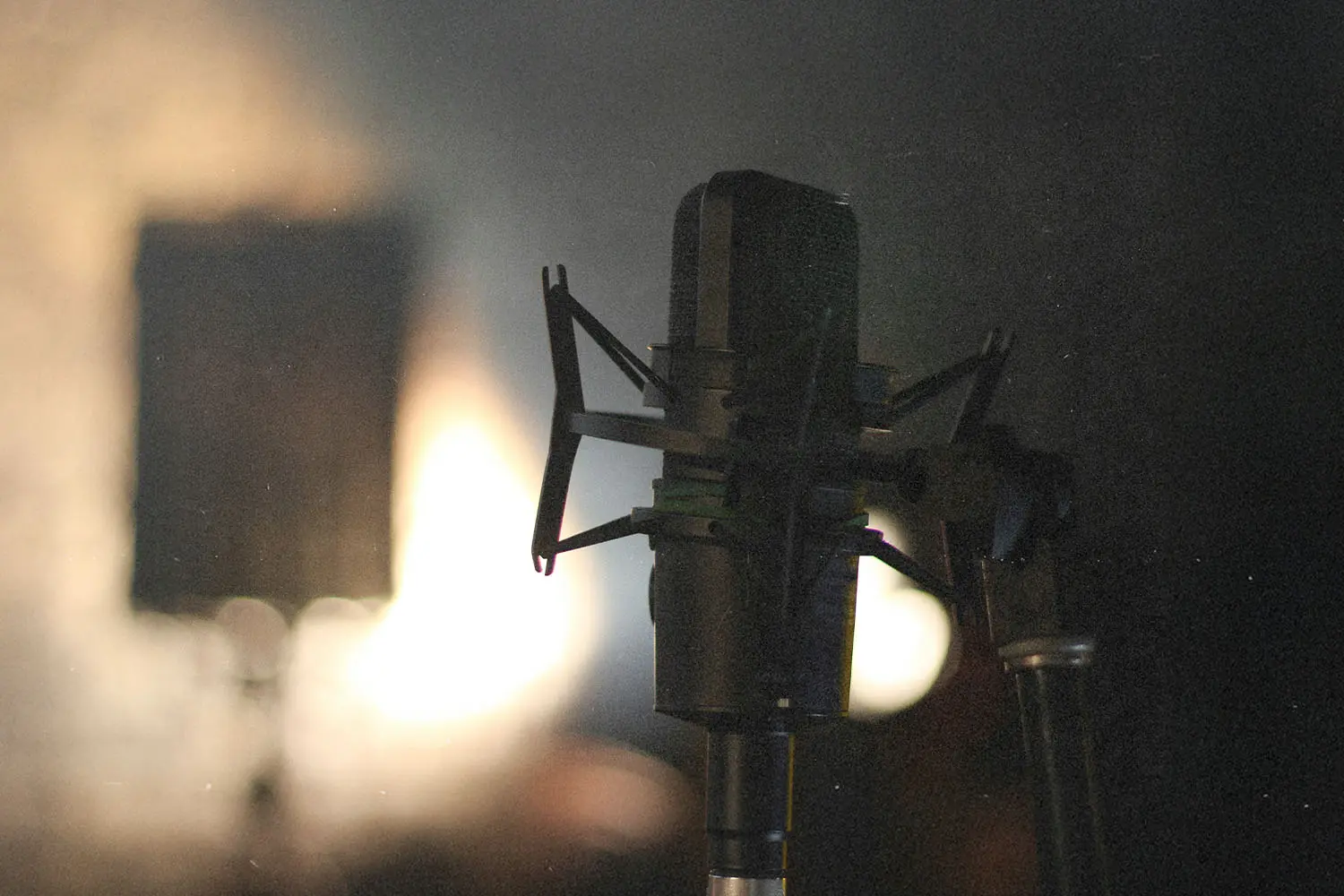 Studio microphone in soft focus with warm backlighting in a dim recording space