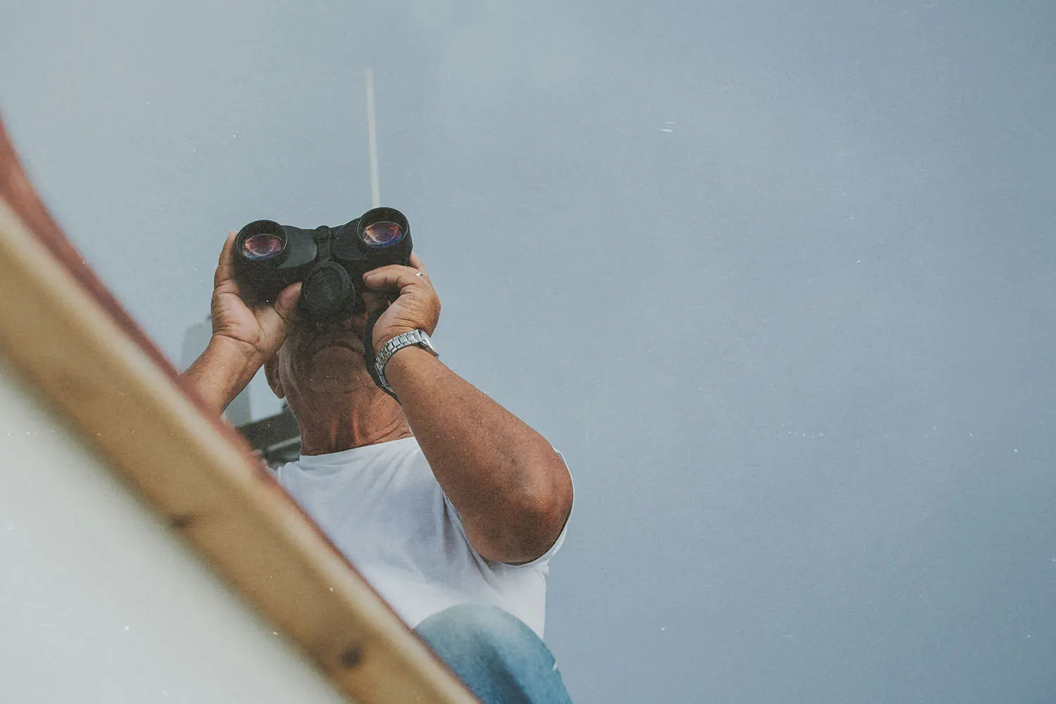 guy on roof looking through binoculars