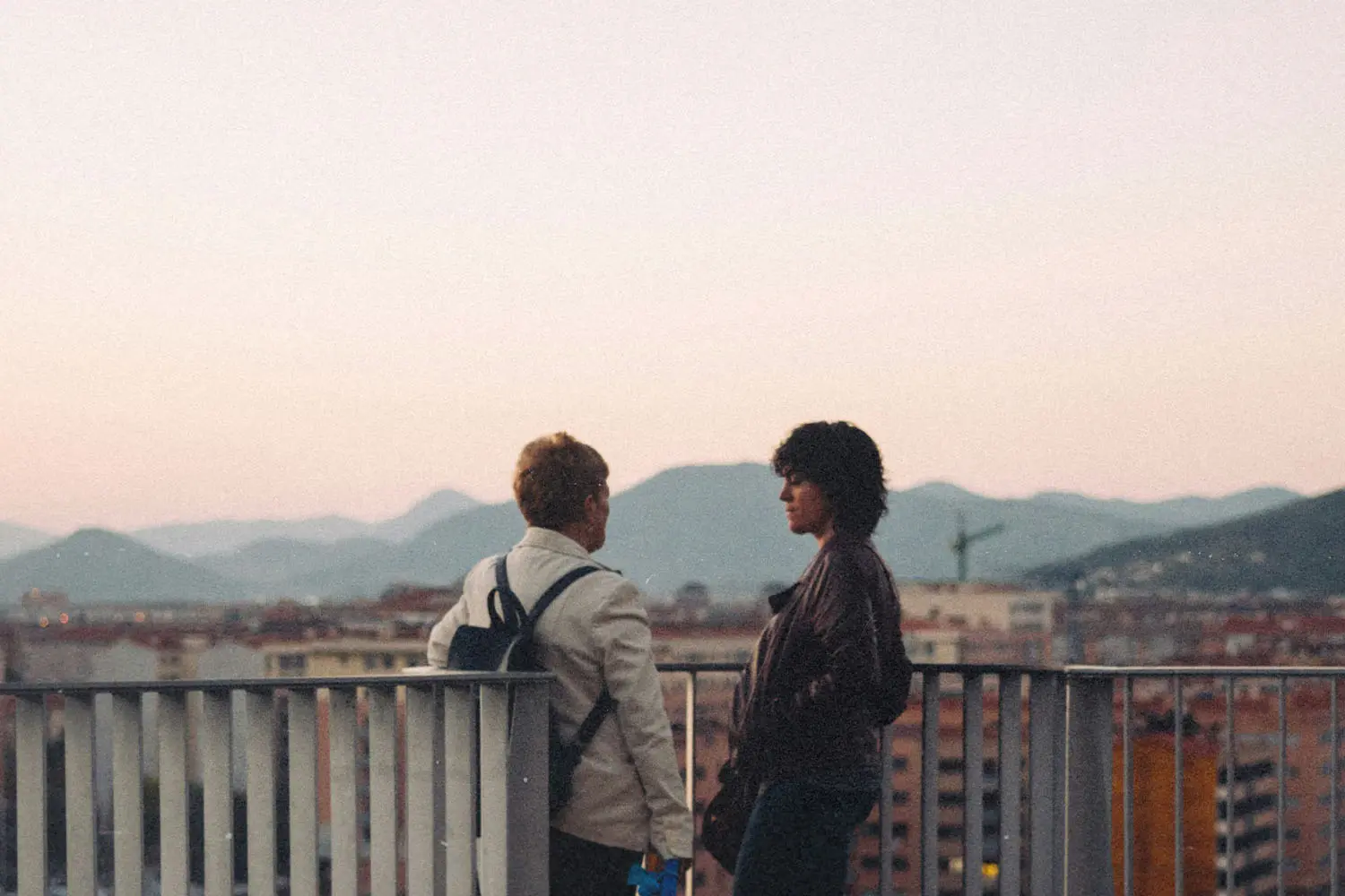 Two people talking on a balcony