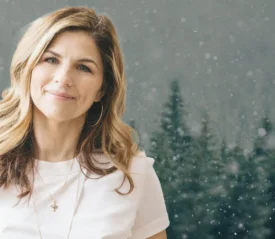 Kellie Copeland smiling in front of winter forest background