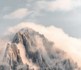 Fog settling over the peak of a snowy mountain